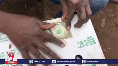 Nghề vá tiền USD ở Zimbabwe