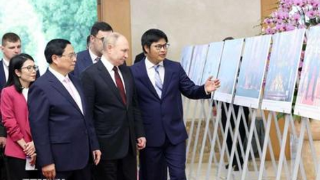 Thủ tướng Phạm Minh Chính và Tổng thống Putin xem trưng bày ảnh của TTXVN