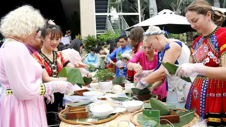 Du khách quốc tế hào hứng gói bánh chưng Tết cổ truyền Việt Nam