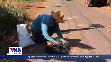 Người đàn ông khuyết tật nhặt đá vá đường